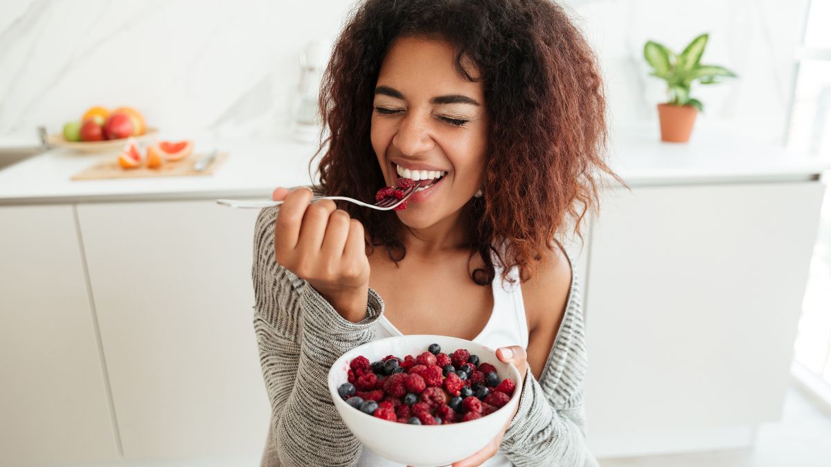 Young woman eating a bowl of healthy berries