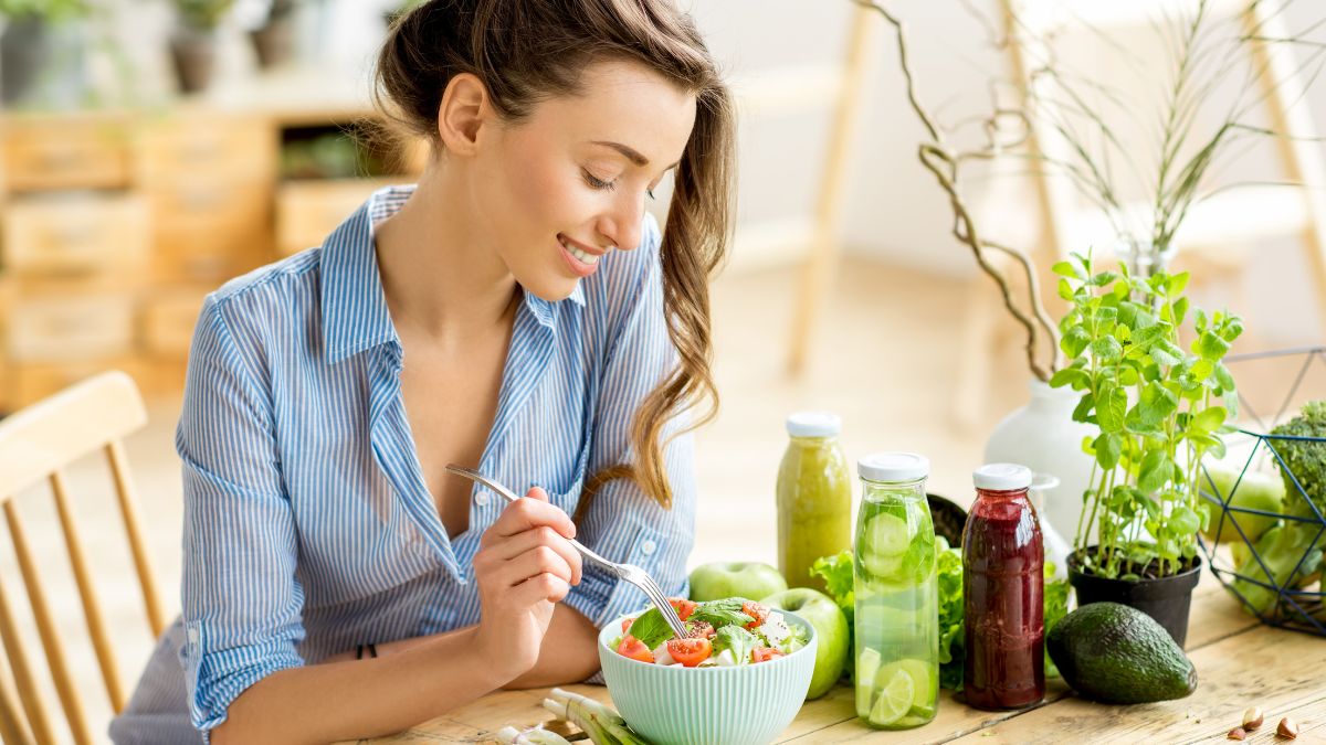 Woman sitting at a table eating a salad